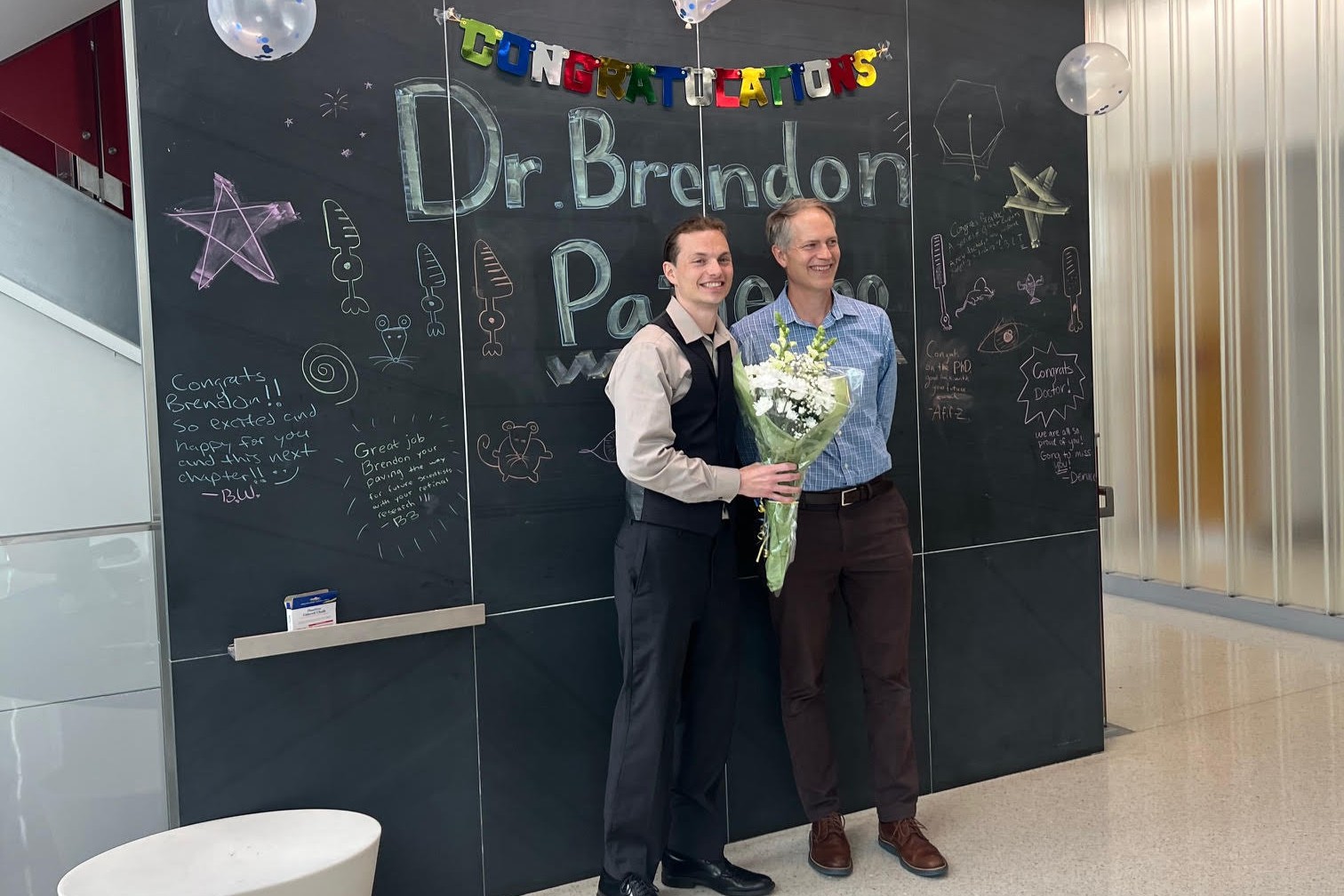 Brendon celebrating his thesis defense with Mark